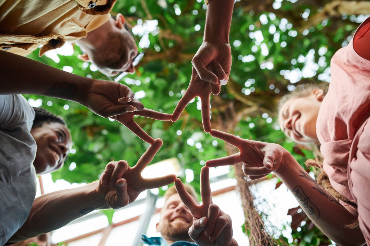 A group of friends creating a star shape with their fingers, symbolizing unity and friendship.